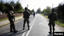 Katonák járőröznek az utcán a lengyelországi Wyryki községben, miután egy drón vagy hasonló tárgy csapódott be egy lakóépületbe a lengyel légtér megsértését követően, egy Ukrajna elleni újabb orosz támadás során, 2025. szeptember 10-én