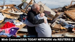 După tornada din 11 decembrie din Dawson Springs, Kentucky, Mike Castle își îmbrățișează fiica. O serie de tornade au lovit mai multe state ale SUA în luna decembrie, un fenomen neobișnuit, care a luat comunitățile și autoritățile prin surprindere.