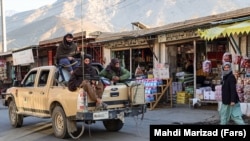 Taliban soldiers ride in a car on a street in Panjshir in December 2021.