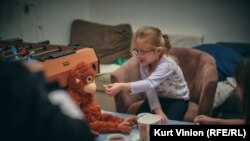 Петгодишната Ева си играе с плюшени играчки в центъра за отдих.