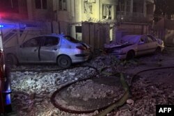 Vehicule distruse în fața unei clădiri din Teheran după un atac israelian în cursul dimineții de 13 iunie 2025.