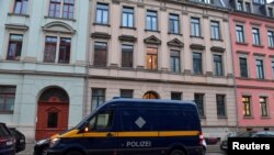 Policijsko vozilo parkirano je ispred zgrade tokom racija na nekoliko lokacija u Drezdenu, Njemačka, 15. decembra 2021.