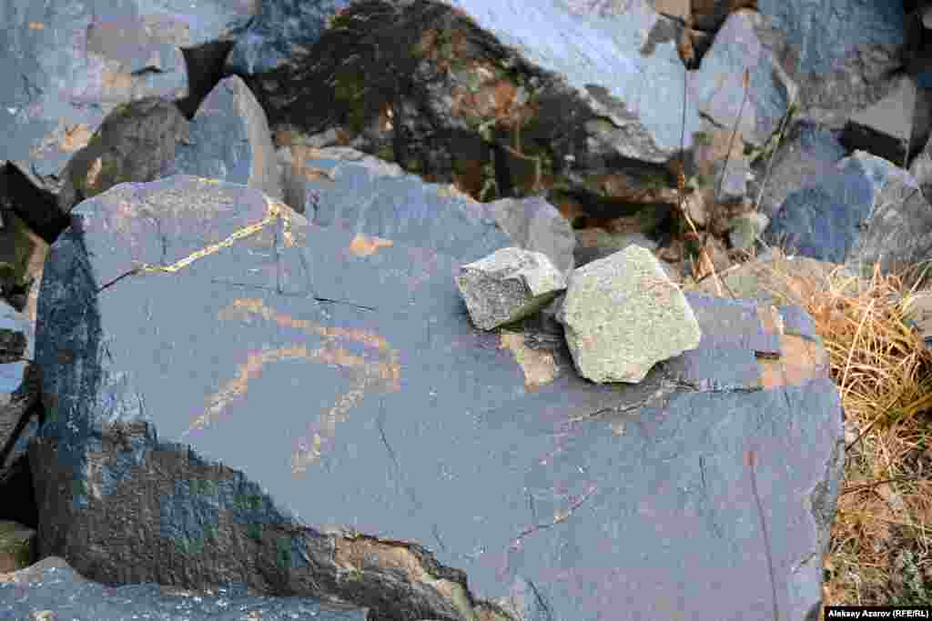 Однако чаще всего петроглифы начинают попадаться на камнях у подножия Кыземшека и в долине ниже нее. Обычно маленькими камнями (турами) на больших камнях горные туристы и альпинисты маркируют тропы, чтобы не сбиться с пути. Здесь же туры сделаны археологами на камнях с наскальными рисунками.