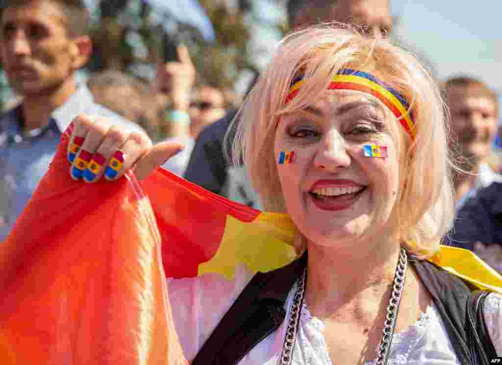 Жена, наметната с флага на Молдова, по време на митинга в Кишинев, 21 май 2023 г.&nbsp; Молдова е бивша съветска република с население от 2,6 милиона души. Страната кандидатства миналата година за присъединяване към ЕС и през юни 2022 г. стана страна кандидат-членка, заедно с Украйна и Грузия. &nbsp;