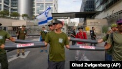 Rezervisti sa rukama u plastičnim cevima u Tel Avivu, 18. jul