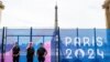 Pripadnici francuske žandarmerije čuvaju stražu ispred sigurnosne ograde ukrašene transparentom Olimpijskih igara Pariz 2024. na Trocadero Esplanade u blizini Eiffelovog tornja u Parizu, 9. jula 2024.