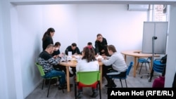 Punëtoret sociale në shoqatën Down Syndrome Kosova në Prizren, Grenita Grazhda dhe Ajgyl Hapqi, duke i ndihmuar anëtarët në punimin e kartolinave.