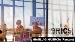 Делегатите поминуваат покрај логото на БРИКС за време на самитот во Јоханесбург, Јужна Африка, на 23 август 2023 година