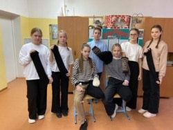 Nxënësit duke pozuar me çorapet që i kanë bërë vetë.