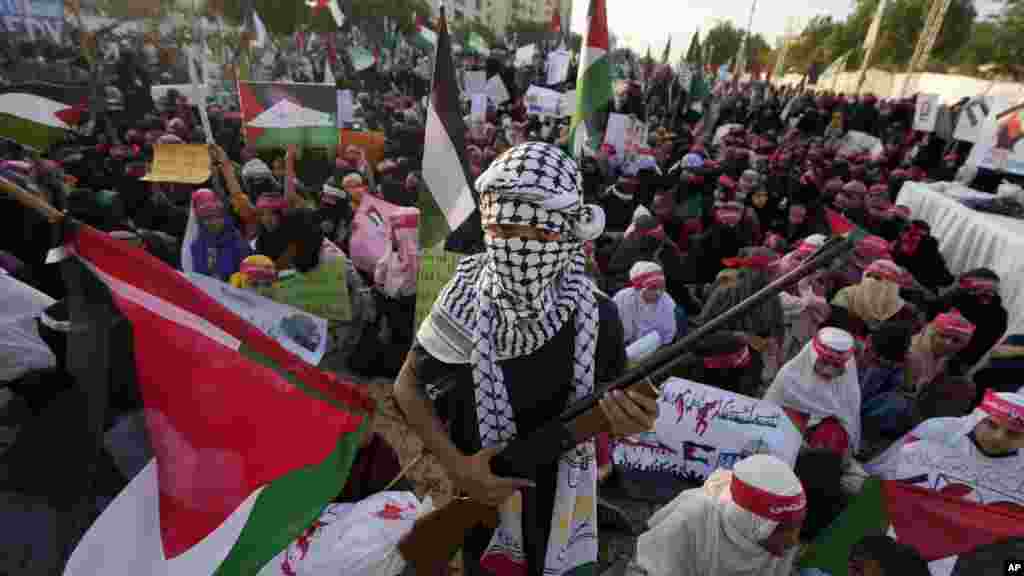 A Pakisztáni Muszlim Liga egyik támogatója, egy fiú légpuskával a kézben 2023. november 12-én a pakisztáni Karacsiban