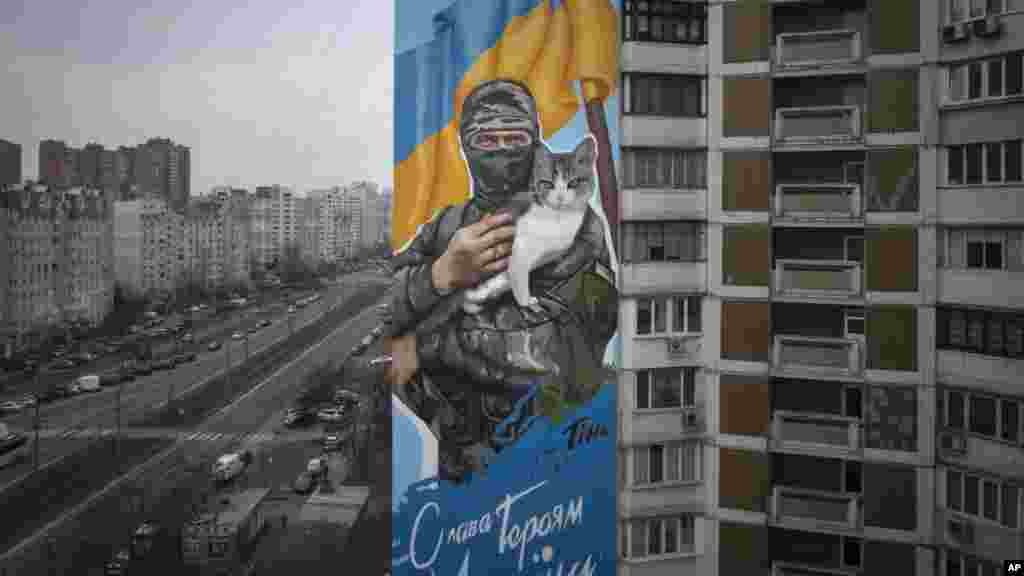 Ez a kijevi graffiti Olekszij Movcsan önkéntes katonát ábrázolja, akit 2022 májusában öltek meg a keleti Donyecki területen, nem sokkal azután, hogy három társával együtt megmentett tizenegy civilt és egy macskát. A kép, amelyet egy Movcsan halála előtt pillanatokkal készült fotó alapján készítettek, egyike annak a kéttucatnyi, háborús témájú falfestménynek, amelyek elesett katonákat, legendás alakokat és a kimerítő konfliktus kulcsmomentumait örökítik meg, és amelyek a város falain jelentek meg azóta, hogy Oroszország két évvel ezelőtt megkezdte teljes körű invázióját