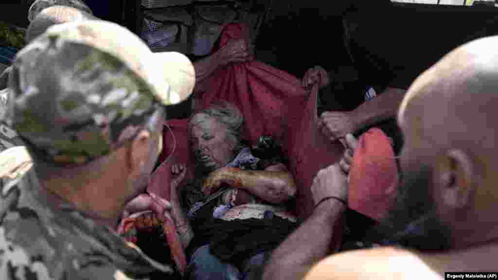 Ukrán katonák egy sérült nőt visznek a mentőautóhoz. Az ukrajnai Donyeck keleti részén fekvő Kosztyantyinivka közel van a frontvonalhoz &nbsp;
