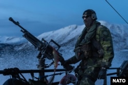 Шведски морски пехотинец стои на палубата на щурмова лодка край бреговете на Норвегия по време на съвместно учение на 1 март.