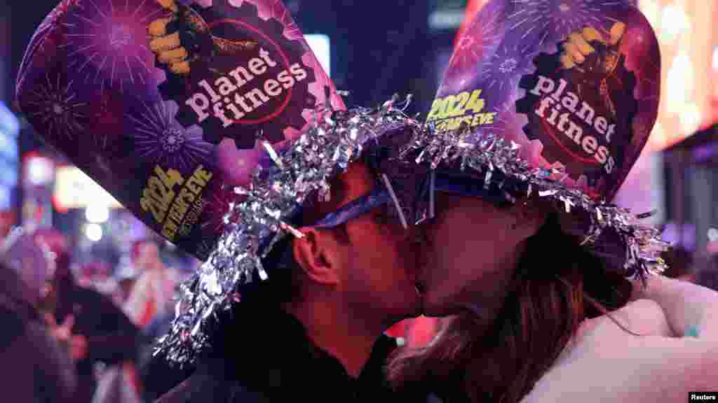 Egy pár csókot vált, miután az óra éjfélt üt a Times Square-en, New Yorkban 2024 szilveszterén