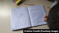 Unul dintre băieții Cristinei Coada, care suferă de dislexie, își face temele pentru acasă.