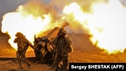 Ushtarët ukrainas duke sulmuar pozicionet ruse afër Bahmutit me një obusë. 21 mars 2023. 