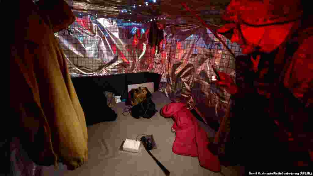 Căptușită cu izolație și luminată de un generator, baraca servește drept casă pentru soldați.