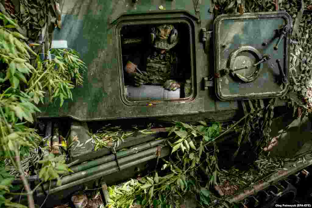  Ukrajinski vojnik piše poruku na raketi samohodne haubice Akatsiya u regionu Donjecka, jula 2023. Ribakova ističe da poruke mogu poslužiti i za podizanje morala vojnika. &quot;Ponekad je to samo bacanje prokletstva na neprijatelja.&quot; Često, dodaje ona, &quot;ljudi zapisuju imena svoje poginule braće i nadaju se da će ih osvetiti ovom granatom&quot;. 