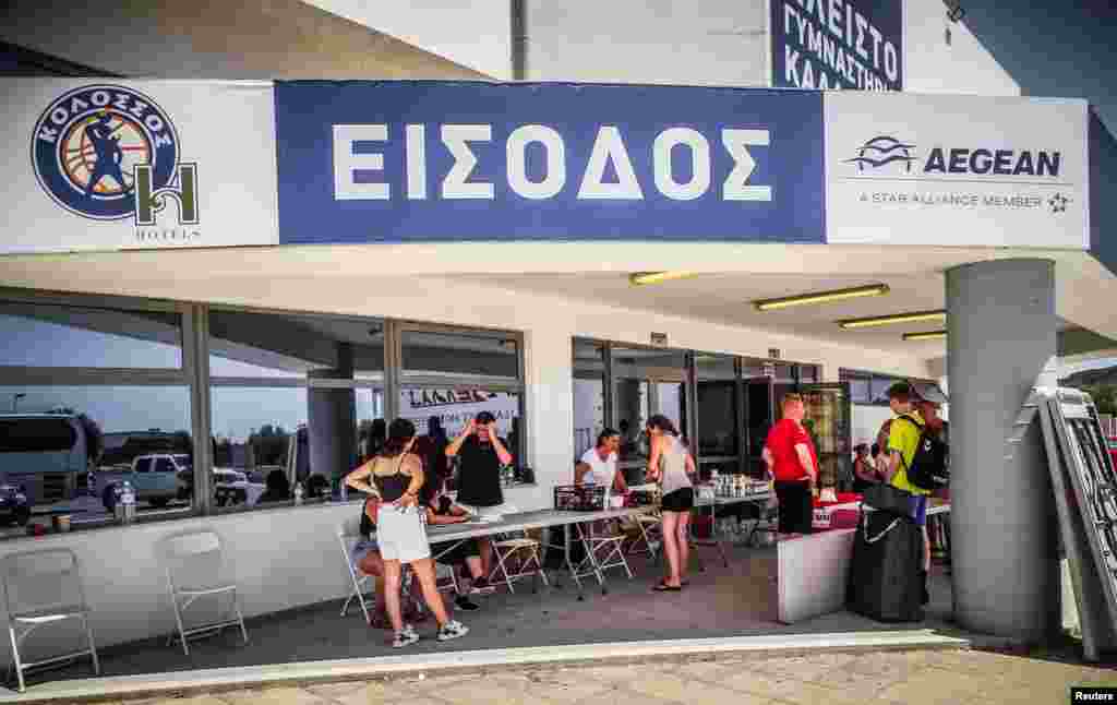 Turisti ispred stadiona nakon što su evakuirani zbog požara.&nbsp; &quot;Ovo je najveća požarna evakuacija ikada u Grčkoj&quot;, izjavila je za AFP Konstantia Dimoglidou, glasnogovornica grčke policije. &quot;Morali smo evakuirati područje od 30.000 ljudi.&quot;