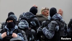 Forca të sigurisë duke e ndaluar një person që ka marrë pjesë në organizimet për t’i dhënë lamtumirën e fundit Aleksei Navalnyt.