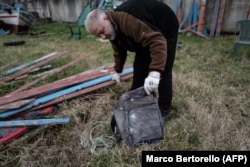 Zatvorenik gleda ruksak koji je migrant ostavio na čamcu nakon iskrcavanja, u dvorištu zatvora u blizini Milana, gdje se reciklira drvo migrantskih čamaca u muzičke instrumente kao dio projekta "Violine mora", februar 2024.