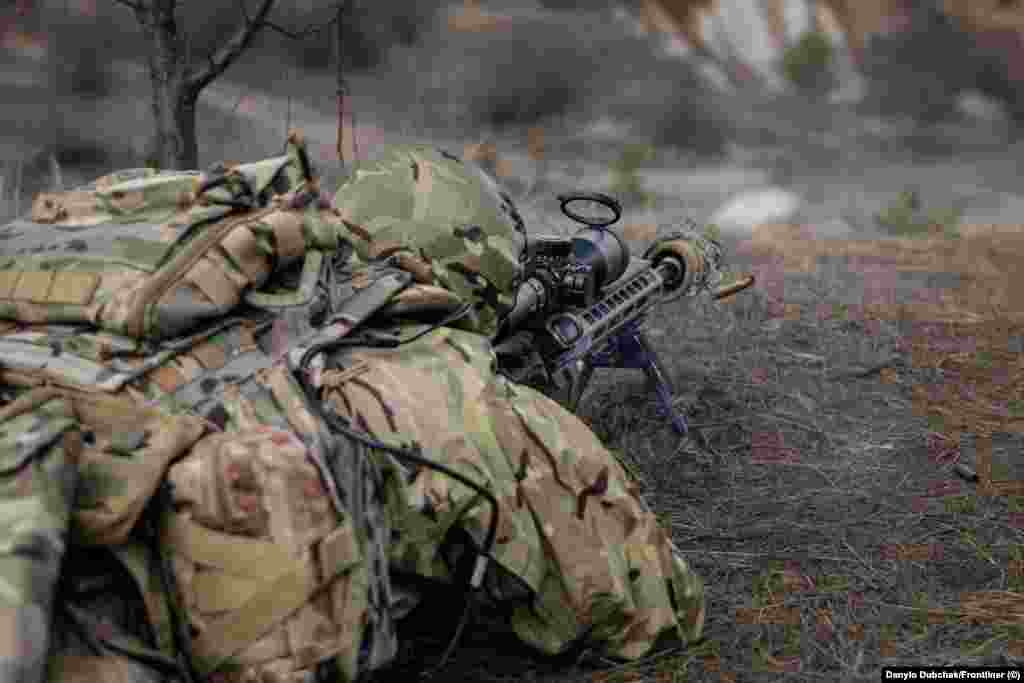 Vojnik ispaljuje metak na obuci. Elanskij kaže da su mnogi bivši snajperisti u Ukrajini prekvalificirani za upravljanje FPV dronovima s oružjem, ali ističe da su skriveni strijelci nezamjenjivi na bojnom polju. &quot;Dronovi ne mogu letjeti po jakoj kiši&quot;, kaže trener, dok &quot;snajperisti mogu pucati po bilo kojem vremenu.&quot;