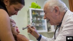 Kozma János gyermekorvos megvizsgál egy gyereket hódmezővásárhelyi rendelőjében 2015. november 2-án (képünk illusztráció)