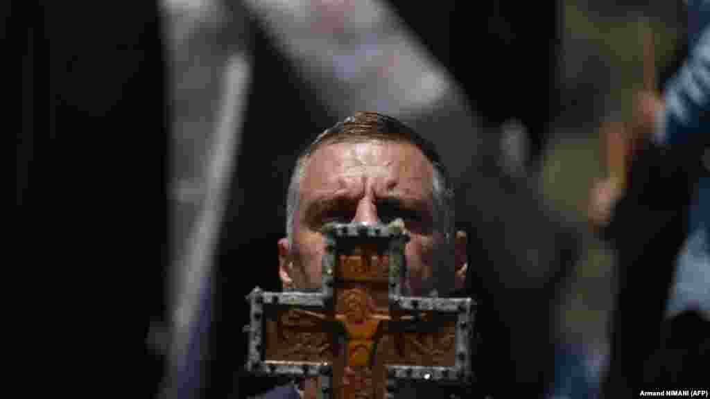 Srbin drži drveni krst tokom komemoracije. U srpskoj poeziji i književnosti se tokom vekova obeležavala bitka koja je imala veliki značaj u nacionalnoj svesti.