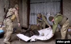 უკრაინელმა სამხედროებმა ბრძოლის ველიდან გამოიტანეს რუსი ჯარისკაცის დასახიჩრებული სხეული