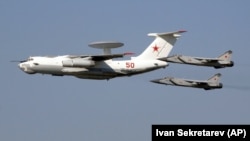 În această fotografie din 11 august 2007, un A-50, echivalentul rusesc al aeronavei americane AWACS, zboară peste Monino, Rusia, la est de Moscova, în timp ce este escortat de avioane interceptoare MiG-31. (imagine generică) 