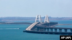 Товарен воз сообраќа по шините на Кримскиот мост, кој ги поврзува руското копно и Кримскиот Полуостров преку теснецот Керч. 17 јули 2023 година. Илустративна фотографијa. 