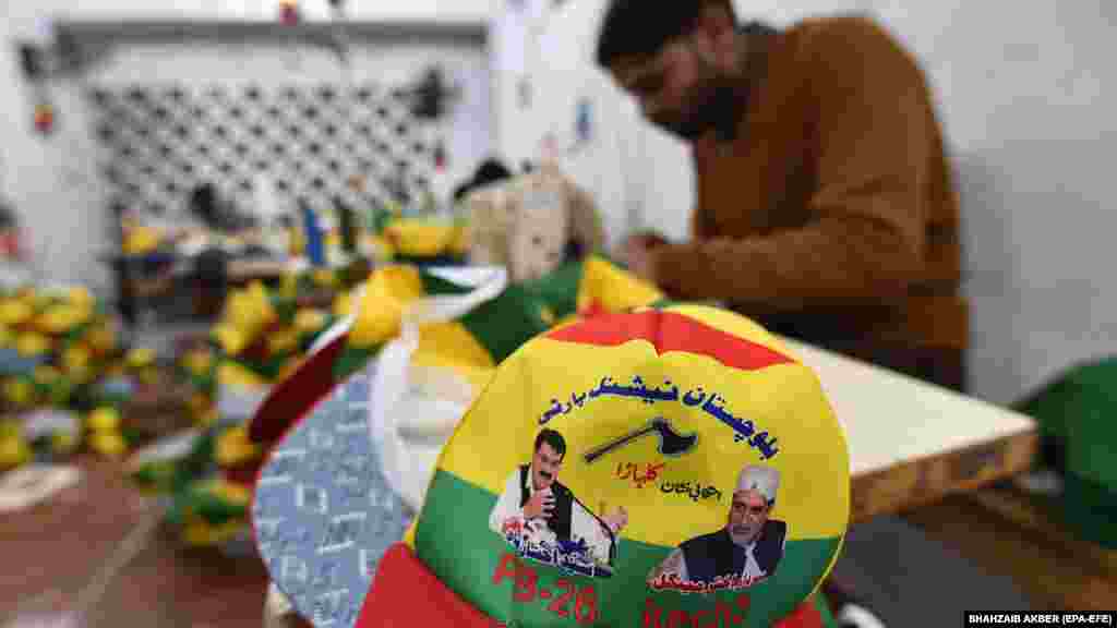 Radnici u Karačiju proizvode bejzbol kape za Nacionalnu partiju Balochistana (Mengal), prikazujući slike stranačkih vođa i njihov simbol sjekire.