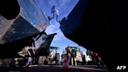 Francuski prosvjednici stoje pored traktora nasuprot žandarmerijskim oklopnim vozilima na autocesti A1 sjeverozapadno od Pariza, 31. siječnja 2024.