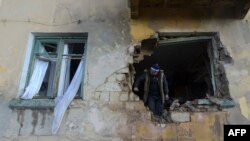 Локален жител го проверува неговиот стан оштетен од неодамнешното гранатирање во Доњецк, Украина. 28 ноември 2023 година.