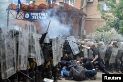 Protestuesit serbë duke goditur pjesëtarë të misionit të NATO-s në Kosovë, KFOR, me shkopinj, në hyrje të ndërtesës komunale në Zveçan, komunë në veri e banuar me shumicë serbe. (Foto: Reuters)