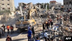 С багери се разчистват отломките на сграда, разрушена от израелски бомбардировки, докато спасители търсят жертви и оцелели в Рафах в южната част на Ивицата Газа на 10 ноември 2023 г.