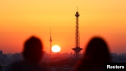 Ljudi gledaju izlazak sunca koje obasjava horizont Berlina, Njemačka, 7. septembra 2023.