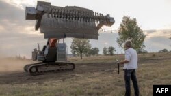 Украинец управлява с дистанционно бронирана машина за разминиране. Кривий риг / Кривой рог, 15 септември 2023 г.