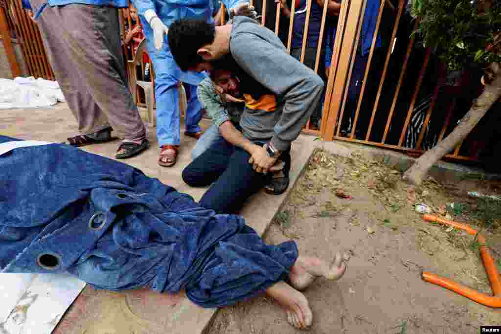 Hozzátartozók az izraeli csapásokban megölt palesztinok holttestei mellett a Gázai övezet déli részén, egy kórház udvarán 2023. október 17-én. Azt követően került sor az evakuálásra, hogy Izrael teljes ostromot rendelt el a Gázai övezetben, válaszul a Hamász egy héttel ezelőtt indított brutális támadására, amelynek legalább ezernégyszáz halottja volt Izraelben