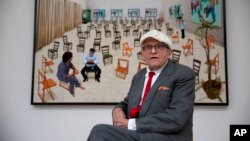 Дейвид Хокни позира пред фотографската си рисунка, отпечатана на хартия, "Столовете", която е част от изложбата "Дейвид Хокни - живопис и фотография" в галерията Annely Juda Fine Art в Лондон, четвъртък, 14 май 2015 г.