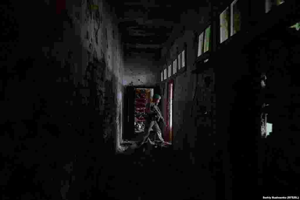 Un soldat în Casa de Cultură din Blahodatne.&nbsp; Un ofițer militar ucrainean a declarat pentru RFE/RL: &bdquo;Din păcate, au existat victime, dar, din fericire, nu numai din partea noastră, ci și din partea Rusiei. Trupele rusești au opus o rezistență încăpățânată, nu au vrut să se predea&rdquo;.