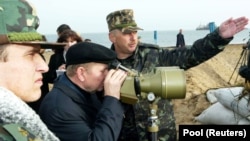 Президент Украины Леонид Кучма на острове Тузла смотрит на российскую дамбу, строительство которой осуществляли от Краснодарского края России, 23 октября 2003 года