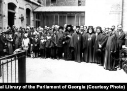 გრიგოლ ფერაძის მღვდლად კურთხევის დღე პარიზში, წმინდა სტეფანეს ბერძნულ ტაძართან. წინ მარჯვნიდან მეექვსე – გრიგოლ ფერაძე, მეშვიდე – ექვთიმე თაყაიშვილი, ხოლო ექვთიმე თაყაიშვილის უკან – აკაკი ჩხენკელი. 1931.