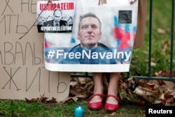 Жена държи плакат с портрет на руския опозиционен лидер Алексей Навални близо до руското посолство в Париж, Франция, 16 февруари 2024 г.
