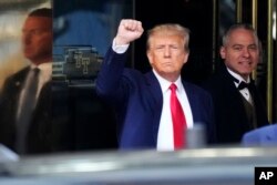 Тръмп напуска с вдигнат юмрък сградата на съда в Манхатън.