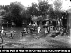 Кадър от Ташкент, днешната столица на Узбекистан, в началото на миналия век. Двама членове на френската експедиция (най-вдясно) наблюдават местните жители.