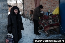 Az önkormányzat által üzemeltett kültéri generátorról töltik a lakosok a telefonjaikat és az akkumulátoraikat Szeverszkben 2023. február 17-én