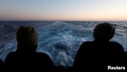 Spašeni migranti gledaju u more sa spasilačkog broda Geo Barents na putu ka italijanskoj luci Bari, Sredozemno more, 25. mart 2023.