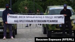 "Руснако, дай своя принос за победата на Украйна над престъпния режим на Путин", пише на плаката, който маскираните руснаци разпънаха пред колите, които даряват за фронта.