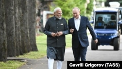 Narendra Modi și Vladimir Putin discută în timpul unei plimbări la reședința din Novo-Ogaryovo, la vest de Moscova.